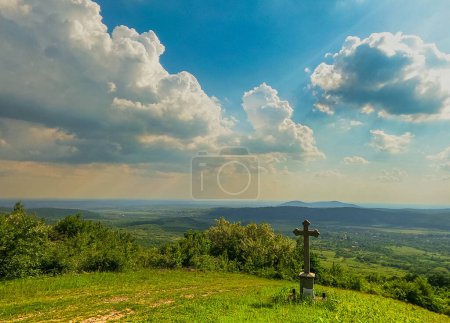 Landschaft mit einem Gottesdienstkreuz in einem Dorf auf dem Berg