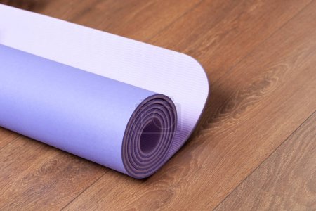 Yoga mat for fitness exercise isolated on a wooden floor