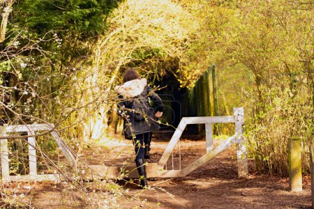 Foto de Una atractiva morena está a punto de entrar en un túnel, que conduce a un mágico paseo por el bosque, en Alfreton, Derbyshire, Inglaterra. - Imagen libre de derechos