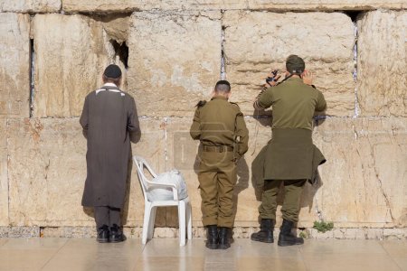 Photo for Israeli army IDF soldiers praying for peace at Western Wall in Jerusalem Old City during war with Hamas in Gaza that led to civilian deaths, hostage kidnapping and humanitarian crisis. - Royalty Free Image