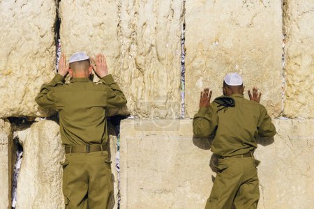 Photo for Israeli army IDF soldiers praying for peace at Western Wall in Jerusalem Old City during war with Hamas in Gaza that led to civilian deaths, hostage kidnapping and humanitarian crisis. - Royalty Free Image