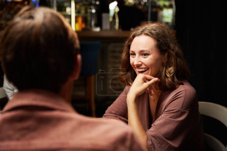 Photo for Happy young caucasian couple wearing casual clothing laughing during dinner at restaurant - Royalty Free Image
