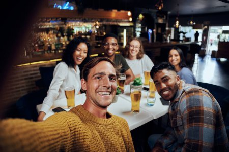 Foto de Joven grupo multirracial de amigos que usan ropa casual sonriendo mientras toman selfie con teléfono móvil - Imagen libre de derechos
