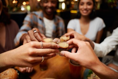 Téléchargez les photos : Gros plan de jeunes amis multiraciaux portant des vêtements décontractés portant un toast avec des photos au restaurant - en image libre de droit