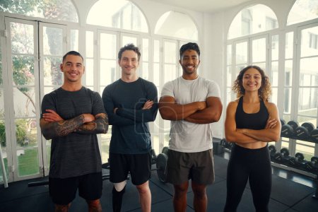 Photo for Group of happy multiracial young adults wearing sportswear looking at camera with arms crossed at the gym - Royalty Free Image