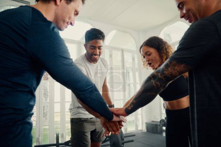 Photo for Group of multiracial young adults wearing sports clothing smiling with hands together at the gym - Royalty Free Image