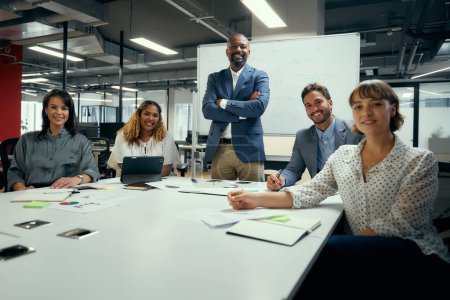 Téléchargez les photos : Portrait de groupe de gens d'affaires multiraciaux en tenue d'affaires souriant lors d'une réunion au bureau de l'entreprise - en image libre de droit