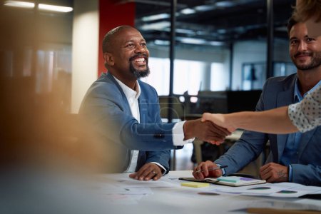 Téléchargez les photos : Quatre hommes d'affaires multiraciaux heureux portant des vêtements d'affaires serrant la main pendant la réunion au bureau - en image libre de droit