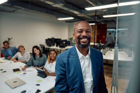 Téléchargez les photos : Groupe de gens d'affaires multiraciaux souriant à côté du tableau blanc lors d'une réunion au bureau de l'entreprise - en image libre de droit