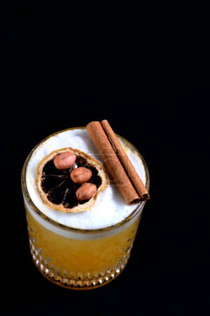 Téléchargez les photos : Agrumes boissons alcoolisées jus de fruits glacés avec cannelle isolé sur fond noir - en image libre de droit