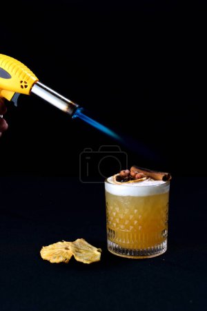 Téléchargez les photos : Agrumes boissons alcoolisées jus de fruits glacés avec cannelle isolé sur fond noir - en image libre de droit