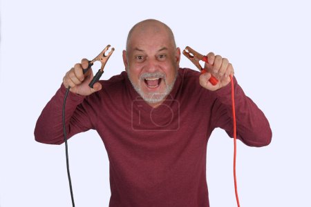 Photo for Adult bald man with white beard holding car battery charger power cable isolated on white background - Royalty Free Image