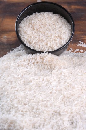 Foto de Arroz blanco arroz largo natural grano crudo comida sana mesa de madera uso textura fondo - Imagen libre de derechos