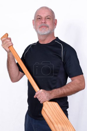Téléchargez les photos : Homme barbu blanc tenant pagaie en bois navigation de l'eau utilisé dans le bateau et les canots - en image libre de droit