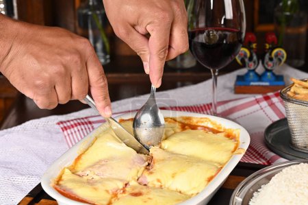 Foto de Lasaña boloñesa al horno con queso jamón salsa roja especias y carne con papas fritas y arroz comida italiana - Imagen libre de derechos