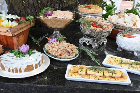 Téléchargez les photos : Table avec buffet varié avec salade de viande macaroni fromage et fruits.. - en image libre de droit