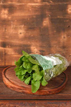 Photo for Arugula leaves on wooden table packaged plant for sale hydroponics business nature - Royalty Free Image