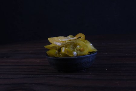 deliciosos chiles jalapeños mexicanos dentro del recipiente aislados sobre fondo negro. sabor