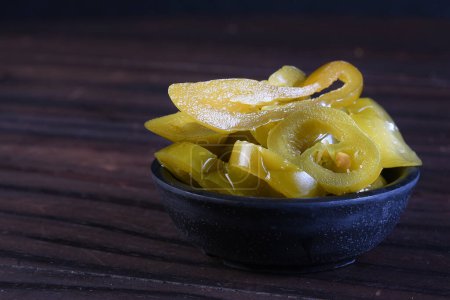 delicious mexican jalapeno peppers inside the canister isolated on black background. taste