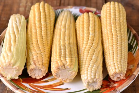 Foto de Maíz comida natural saludable delicioso vegano cocido maíz verde en madera mesa sabor - Imagen libre de derechos