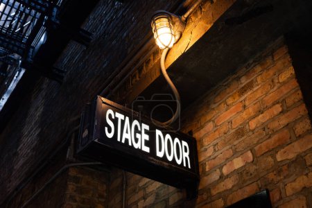 Stage door sign in downtown Chicago alley.