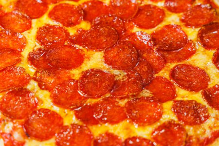 Téléchargez les photos : Pizza tranchée à la saucisse, sauce tomate, mozzarella, oignon et tranche de pâte, garnie de fromage à la crème sur fond noir - en image libre de droit