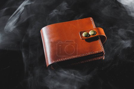 Photo for Stylish handmade brown leather wallet on a gray background. Product made of genuine leather. - Royalty Free Image