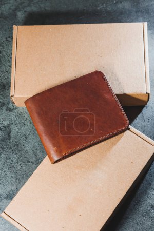 Photo for Stylish handmade brown leather wallet on a gray background. Product made of genuine leather. - Royalty Free Image