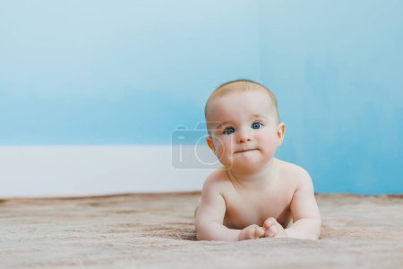 Photo for Little cute baby lying on tummy and holding head, child development. - Royalty Free Image
