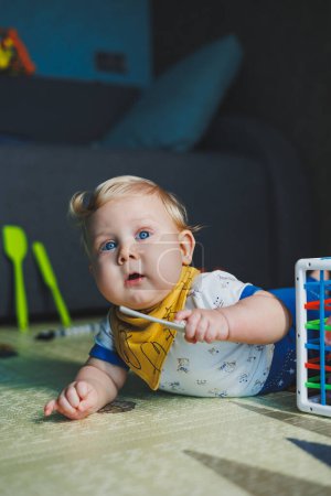The child is lying on the mat, playing with soft balls. Educational toys for the motor skills of the baby's hands. Child development. Sensory experience