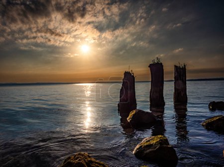 Foto de Poste de amarre de madera al amanecer en el lago de Garda - Imagen libre de derechos