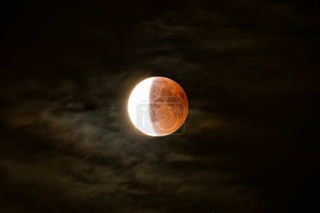 Eclipse lunar de cerca en una noche nublada