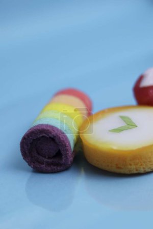 Mini rainbow roll cake with super delicious taste, Lapindo kue lumpur is a traditional Indonesian wet cake, and delicious market snack, blue background.