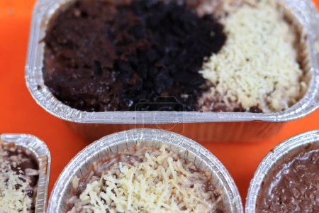 Téléchargez les photos : Brownies fondus saupoudrés de fromage et délicieux chocolat sont sur un plateau orange sur un fond blanc - en image libre de droit