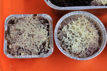 Foto de Brownies derretidos espolvoreado con queso y delicioso chocolate están en una bandeja de naranja sobre un fondo blanco - Imagen libre de derechos