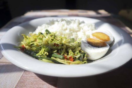 Foto de Menú de comer flores de papaya saladas y huevos salados es bueno para la salud. tumis bunga pepaya - Imagen libre de derechos