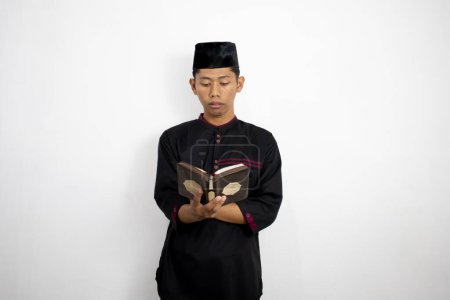 Téléchargez les photos : Jeune homme musulman livre de lecture - en image libre de droit