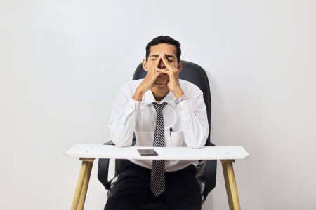 Foto de Cansado asiático hombre sentado en oficina - Imagen libre de derechos