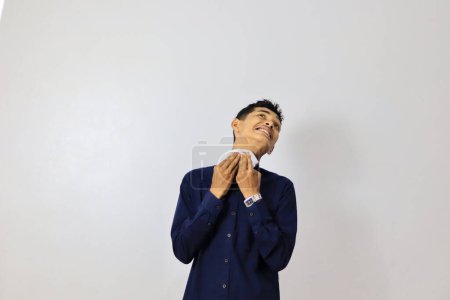 Foto de Joven asiático hombre de negocios limpiando su cara en blanco fondo - Imagen libre de derechos