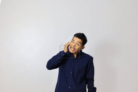 Photo for Young asian businessman wiping his face on white background - Royalty Free Image