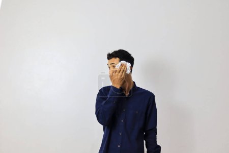 Foto de Joven asiático hombre de negocios limpiando su cara en blanco fondo - Imagen libre de derechos