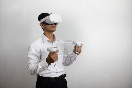 Foto de Hombre joven con camisa blanca ordenada usando auriculares de realidad virtual. Aislado sobre retrato de estudio de fondo blanco. VR, futuro, gadgets, tecnología, educación en línea, aprendizaje, concepto de videojuegos - Imagen libre de derechos
