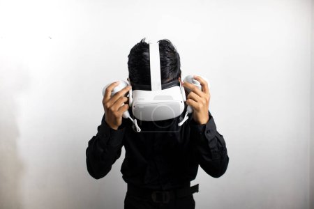 Foto de Hombre joven con camisa negra ordenada usando auriculares de realidad virtual. Aislado sobre retrato de estudio de fondo blanco. VR, futuro, gadgets, tecnología, educación en línea, aprendizaje, concepto de videojuegos - Imagen libre de derechos