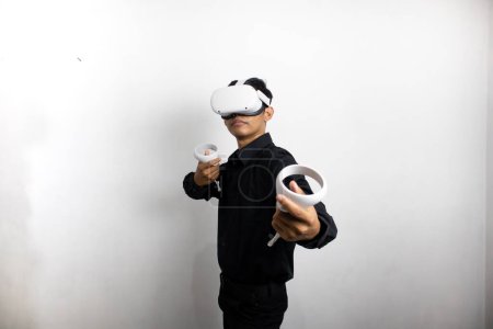 Foto de Hombre joven con camisa negra ordenada usando auriculares de realidad virtual. Aislado sobre retrato de estudio de fondo blanco. VR, futuro, gadgets, tecnología, educación en línea, aprendizaje, concepto de videojuegos - Imagen libre de derechos