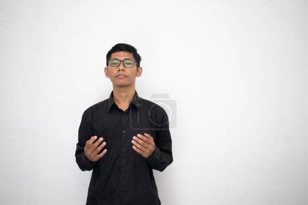 Téléchargez les photos : Asiatique homme en pur noir vêtements prie sur fond de studio - en image libre de droit