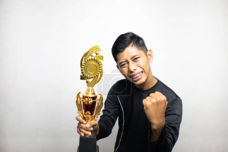 Foto de Guapo asiático hombre en negro ropa celebración de oro trofeo taza, blanco estudio fondo - Imagen libre de derechos