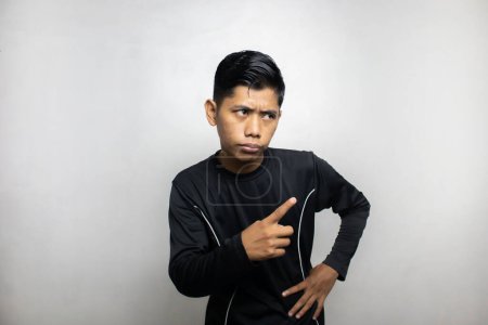 Téléchargez les photos : Émotionnel asiatique l'homme dans noir vêtements posant sur blanc studio fond - en image libre de droit