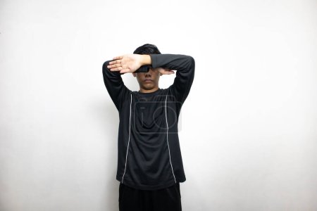 Emotional asian man in black clothes posing on white studio background 