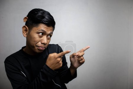 Foto de Emocional asiático hombre en negro ropa posando en blanco estudio fondo - Imagen libre de derechos