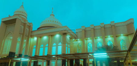 Foto de - 31 de julio de 2021: Mezquita iluminada bajo el cielo nublado al atardecer - Imagen libre de derechos
